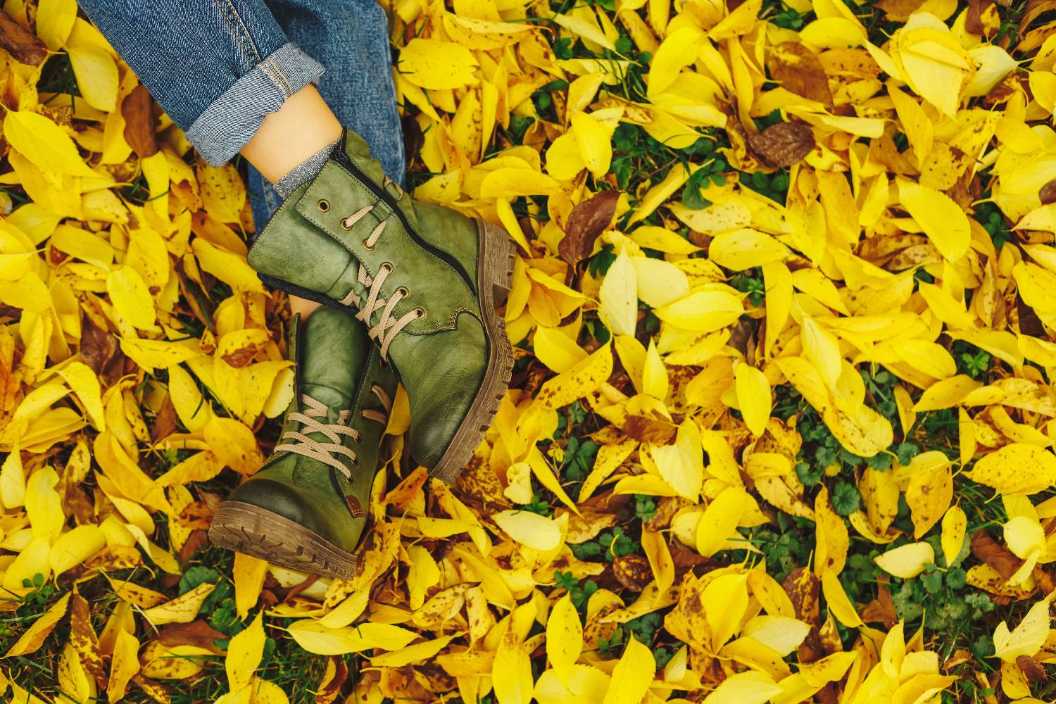 green boots shot against yellow leaves